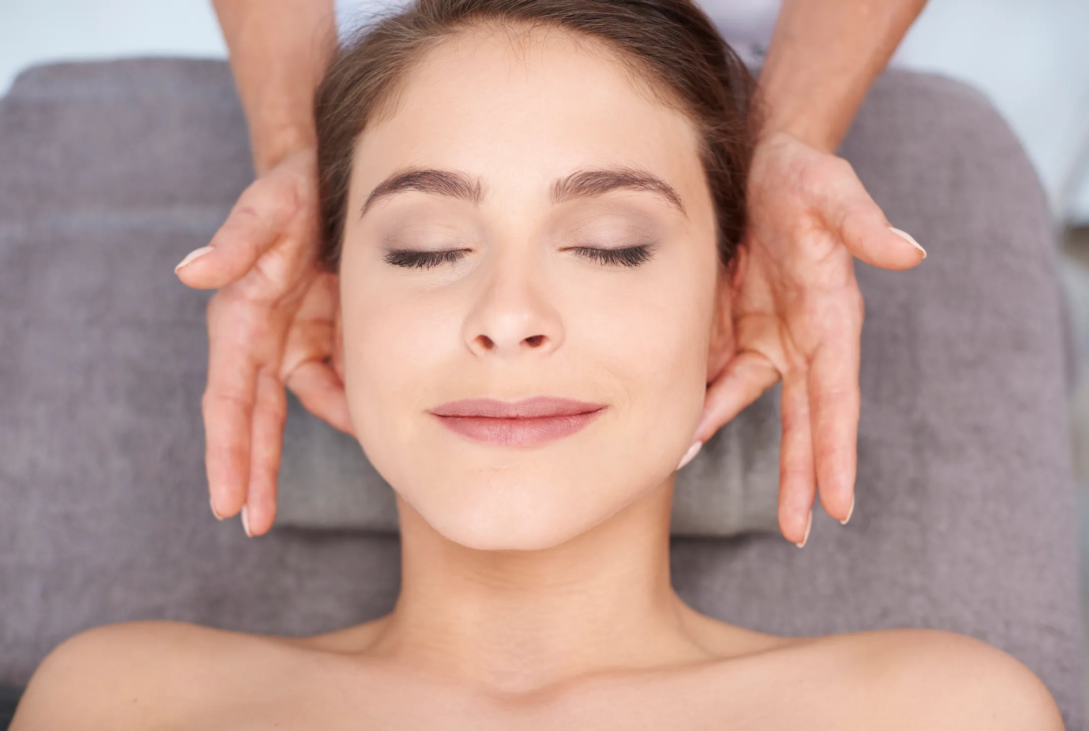 Femme les yeux fermés pendant un massage du visage